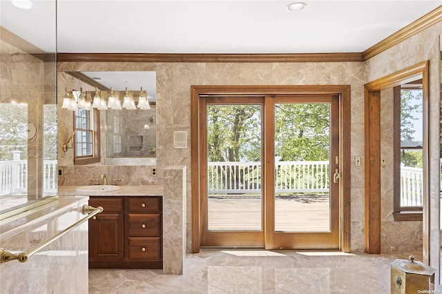 bathroom featuring vanity, crown molding, and tile walls