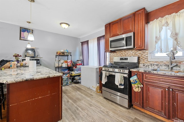 kitchen with sink, plenty of natural light, light hardwood / wood-style flooring, and appliances with stainless steel finishes