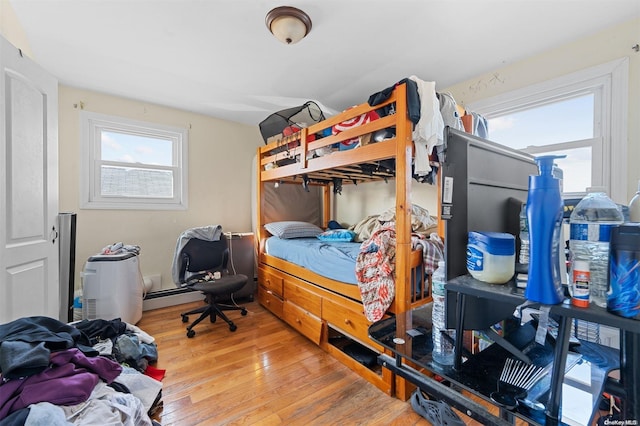 bedroom featuring baseboard heating and wood-type flooring