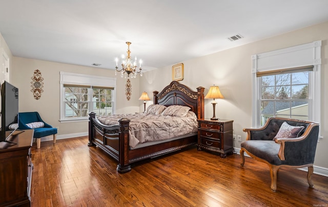 bedroom featuring multiple windows, an inviting chandelier, and hardwood / wood-style flooring