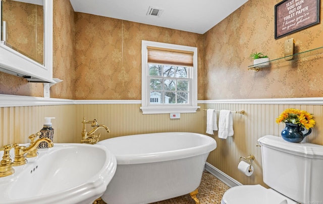 bathroom with toilet, sink, and a tub