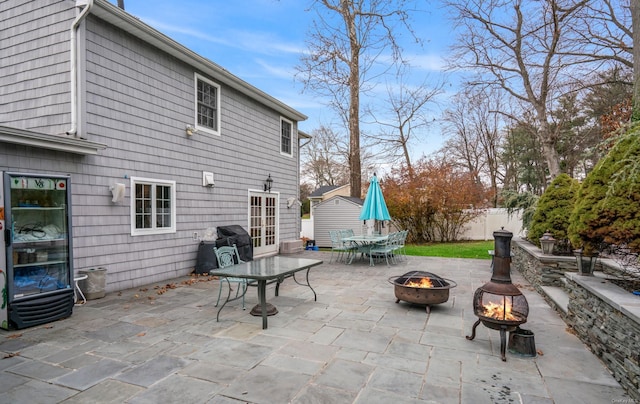 view of patio / terrace with a fire pit and a storage unit