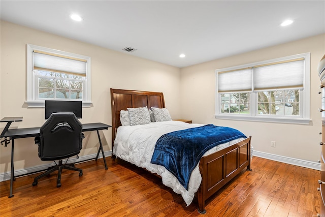 bedroom featuring multiple windows and hardwood / wood-style floors