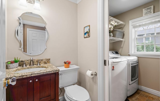 bathroom featuring vanity, toilet, and washing machine and clothes dryer