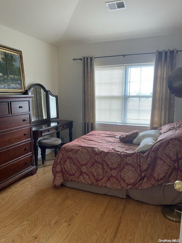 bedroom featuring vaulted ceiling and light wood-type flooring