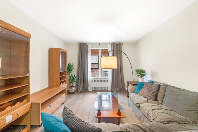 living room with radiator heating unit, plenty of natural light, and light hardwood / wood-style flooring