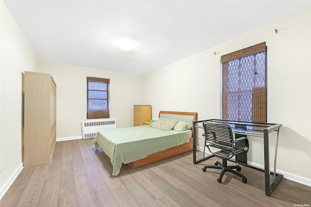 bedroom with radiator and light hardwood / wood-style flooring