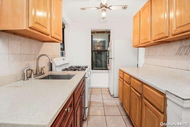 kitchen featuring white appliances, backsplash, sink, ceiling fan, and light tile patterned floors