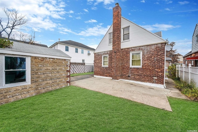 back of house with a yard and a patio