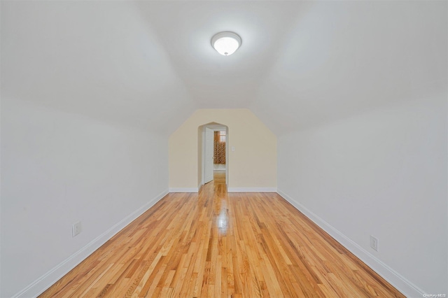 additional living space featuring light hardwood / wood-style floors and vaulted ceiling