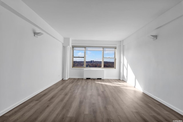 unfurnished room with wood-type flooring and radiator