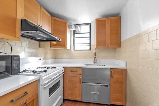 kitchen featuring white range oven, dark tile patterned floors, and sink