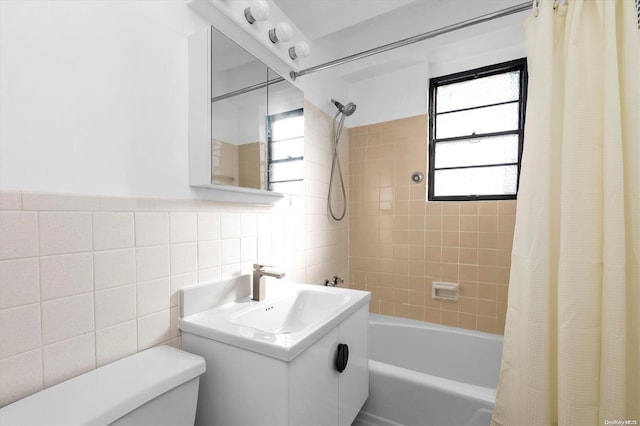 full bathroom with sink, shower / bathtub combination with curtain, tile walls, and toilet