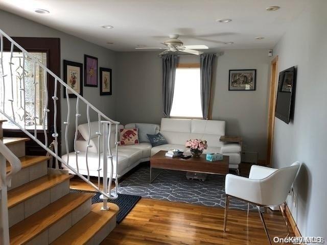 living room with hardwood / wood-style flooring and ceiling fan