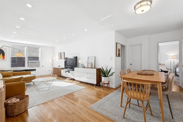 dining area with light hardwood / wood-style floors and cooling unit