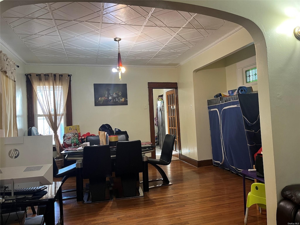 dining area with ornamental molding and dark hardwood / wood-style floors