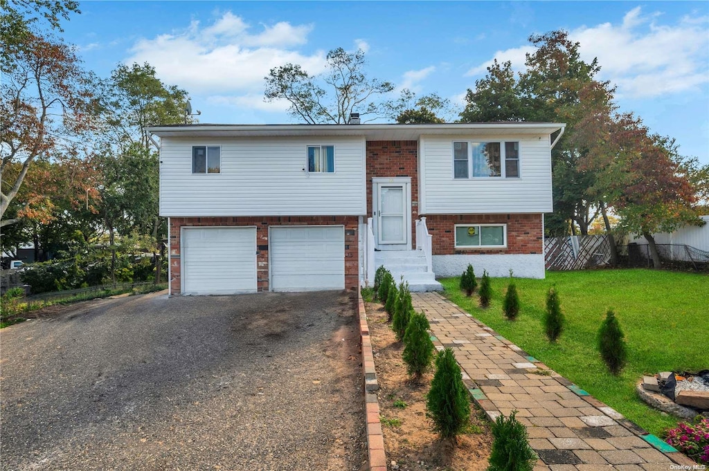 bi-level home featuring a garage and a front lawn