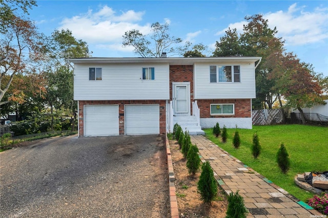 bi-level home featuring a garage and a front lawn