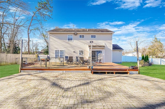 rear view of property with a lawn and a wooden deck