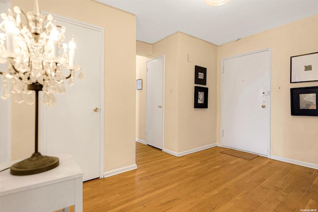 foyer entrance with a chandelier and light hardwood / wood-style flooring