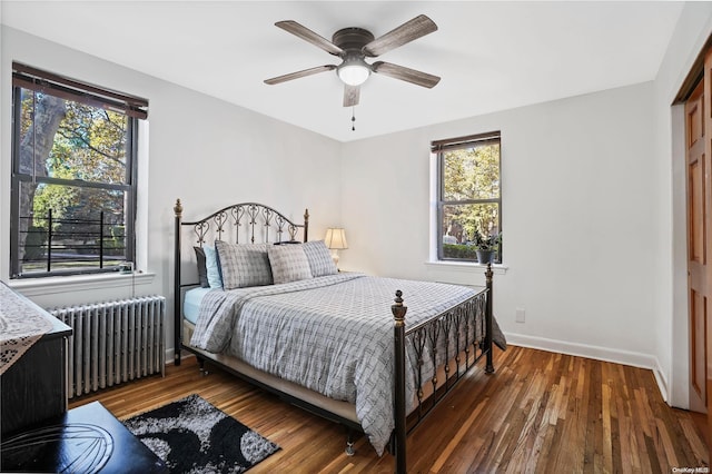 bedroom with a closet, dark hardwood / wood-style floors, radiator, and ceiling fan