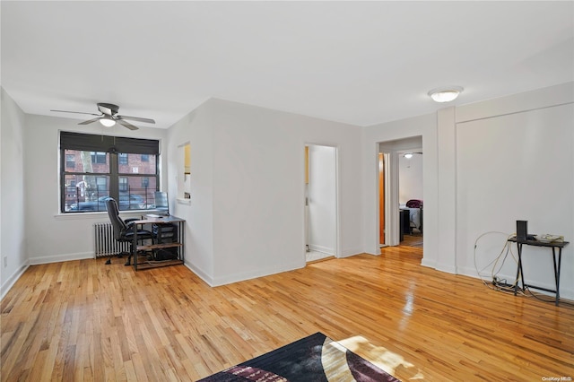 living room with radiator, light hardwood / wood-style floors, and ceiling fan