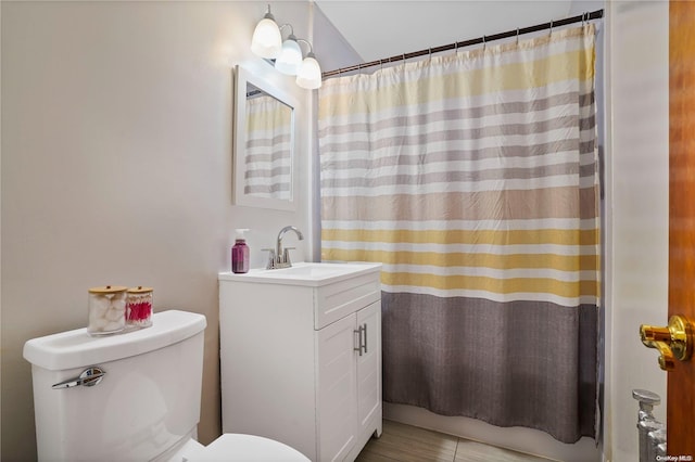 bathroom with tile patterned flooring, vanity, and toilet