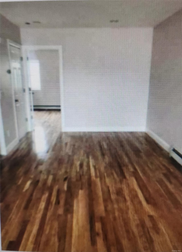 unfurnished room with hardwood / wood-style flooring