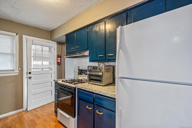 kitchen featuring a textured ceiling, light hardwood / wood-style floors, white appliances, and blue cabinetry