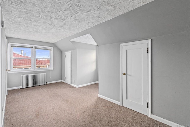 bonus room featuring carpet, radiator heating unit, a textured ceiling, and lofted ceiling