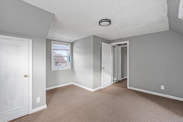 bonus room featuring carpet, a textured ceiling, and vaulted ceiling