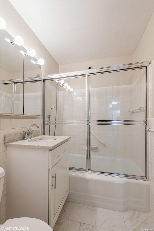 full bathroom with vanity, toilet, and combined bath / shower with glass door