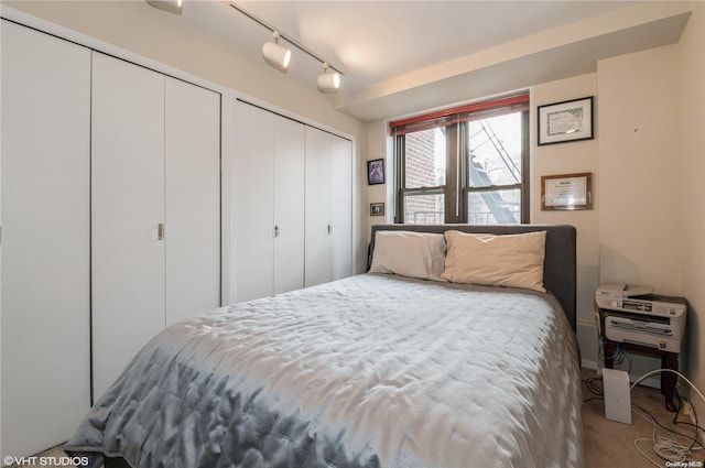 bedroom with rail lighting and carpet floors