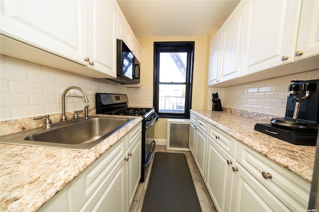 kitchen featuring black appliances, white cabinets, and sink