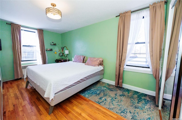 bedroom featuring wood-type flooring and multiple windows