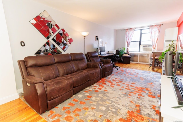 living room with radiator, cooling unit, and wood-type flooring