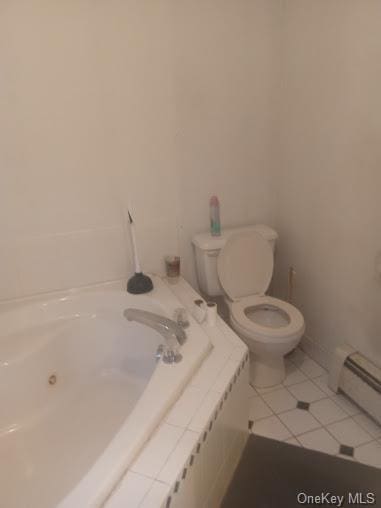 bathroom featuring a tub to relax in, toilet, tile patterned flooring, and baseboard heating