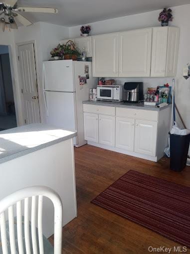 kitchen with ceiling fan, white cabinets, dark hardwood / wood-style floors, and white appliances