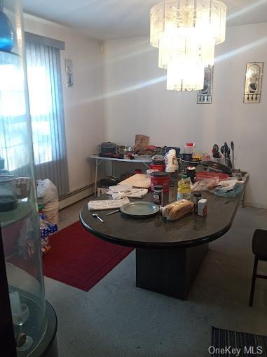 dining area featuring baseboard heating and a notable chandelier