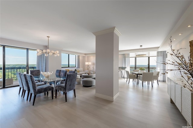 dining room with crown molding, an inviting chandelier, and light wood-type flooring