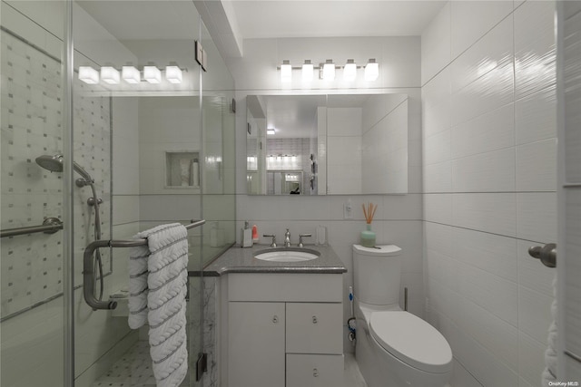 bathroom with vanity, toilet, an enclosed shower, and tile walls