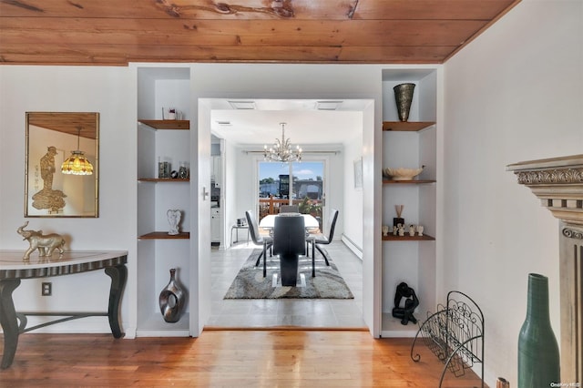 dining space featuring hardwood / wood-style floors, a notable chandelier, wooden ceiling, and built in shelves