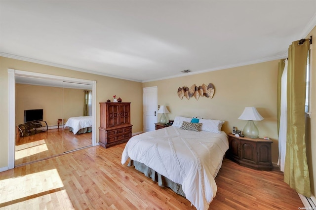 bedroom with light wood-type flooring and crown molding