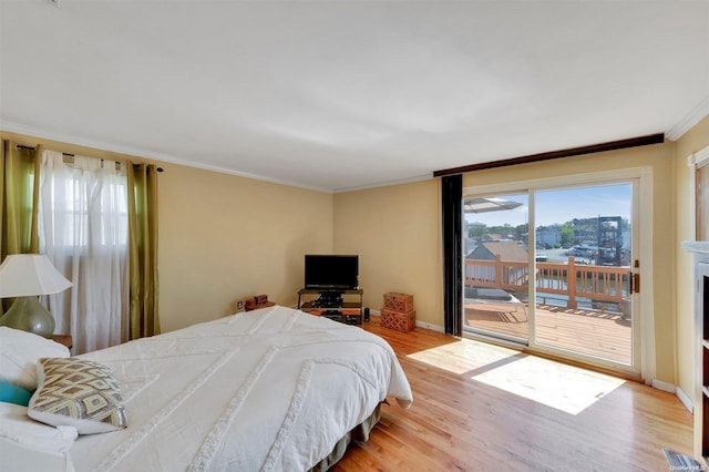 bedroom with access to outside, light hardwood / wood-style flooring, and crown molding