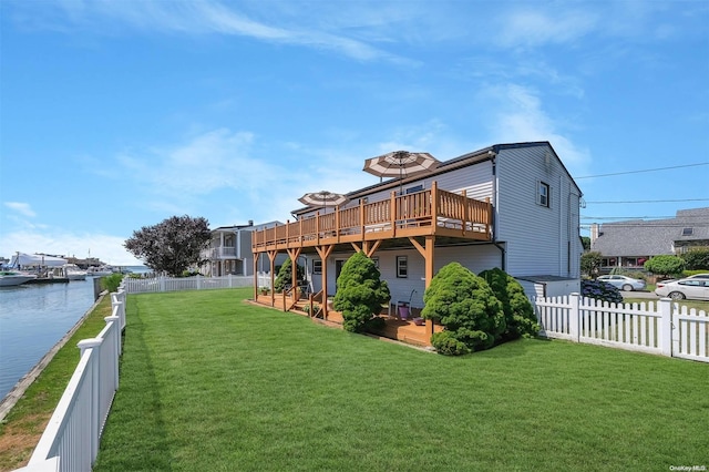 back of property featuring a lawn and a deck with water view