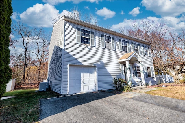 view of front of home with central air condition unit and a garage