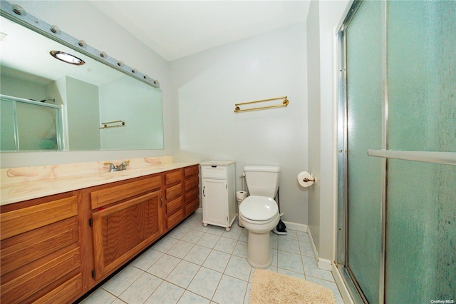 bathroom with tile patterned flooring, vanity, toilet, and a shower with shower door