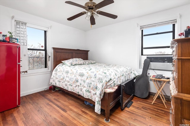 bedroom featuring multiple windows, ceiling fan, and dark hardwood / wood-style flooring