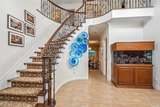 stairway with a high ceiling and ornamental molding