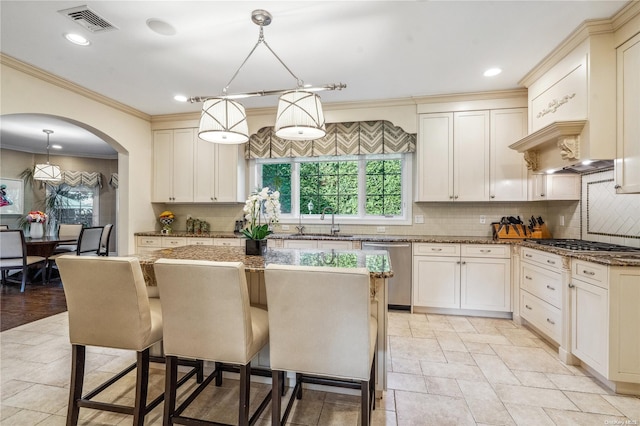 kitchen with a kitchen breakfast bar, a kitchen island, decorative light fixtures, and appliances with stainless steel finishes